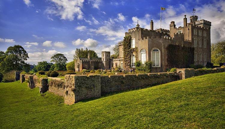 Powderham Castle With Blue Skies And Trees
